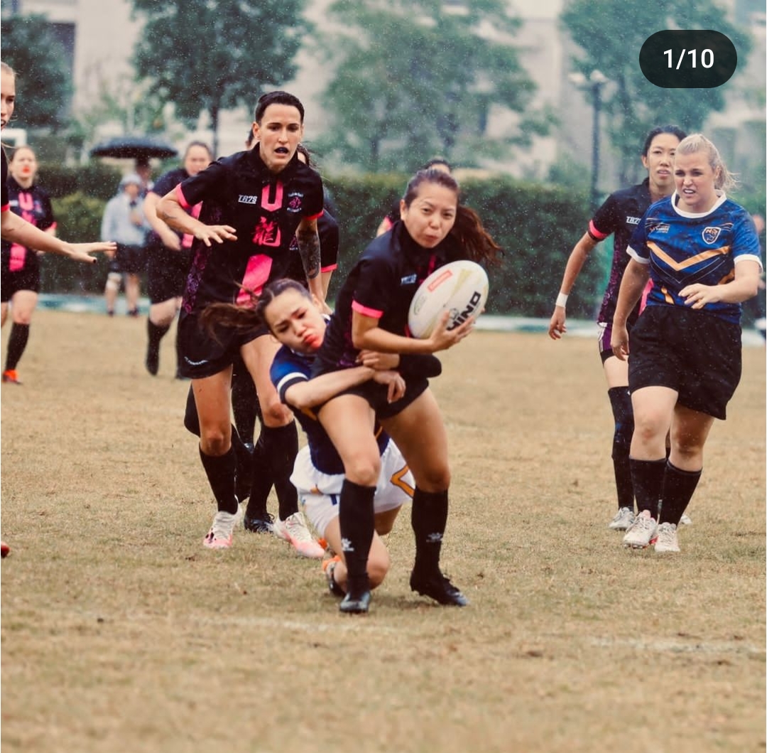 Haena passing the ball during a rugby match in the rain